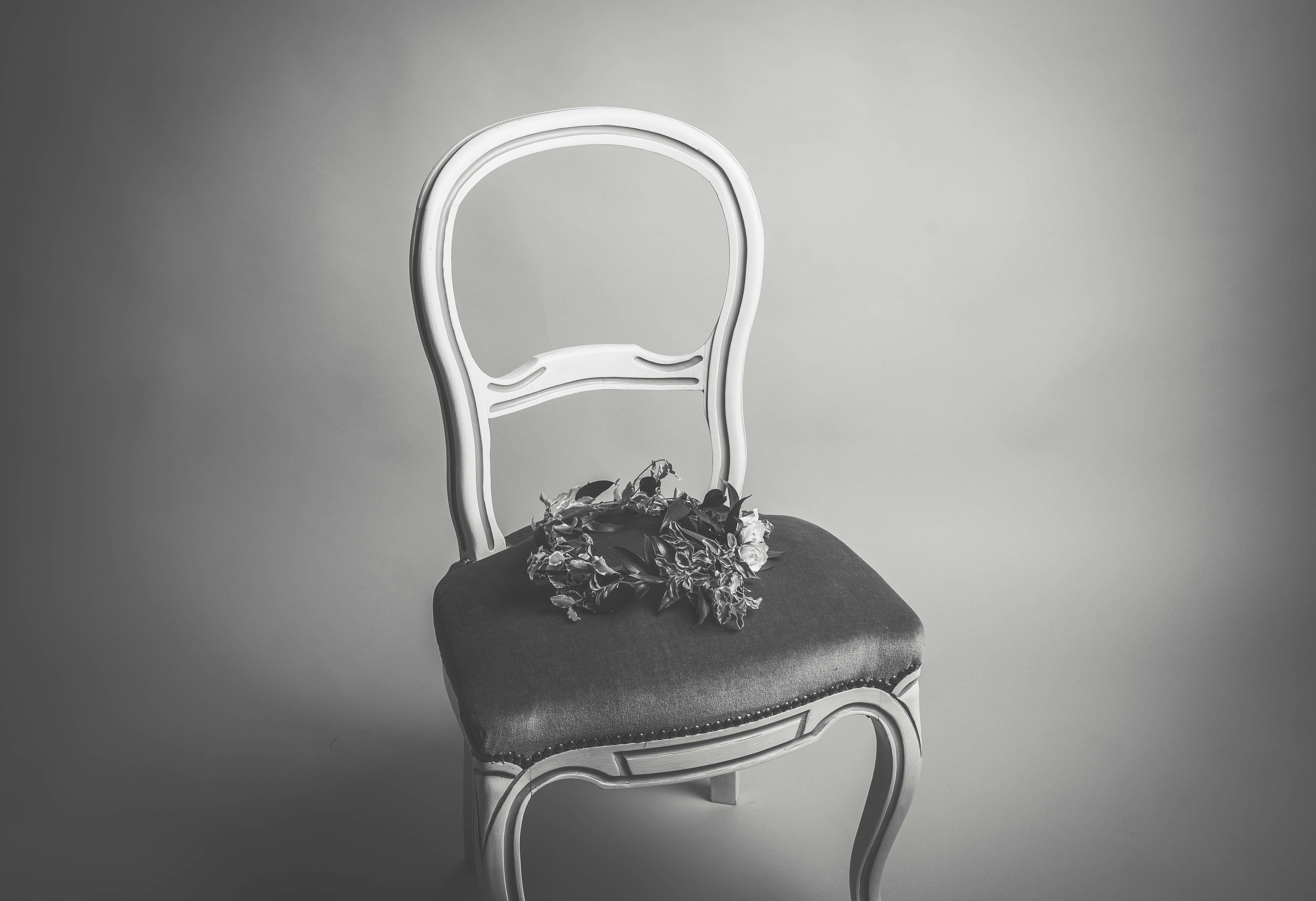 grayscale photography flower circlet on armless chair